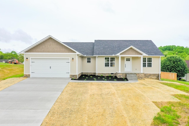 craftsman house featuring an attached garage, concrete driveway, covered porch, a shingled roof, and a front lawn