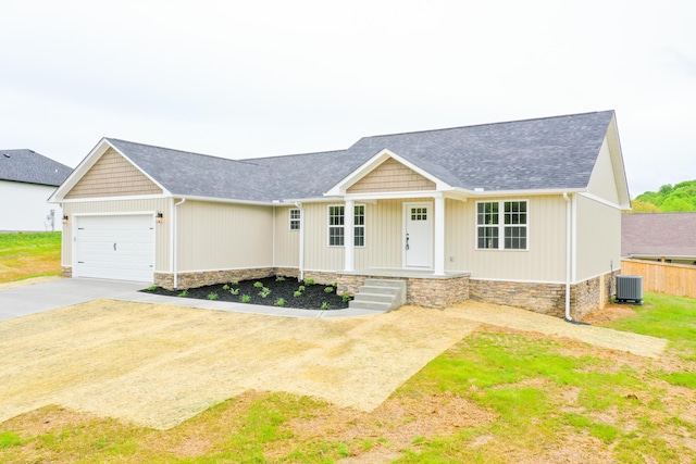 view of front of home with cooling unit, concrete driveway, an attached garage, roof with shingles, and a porch