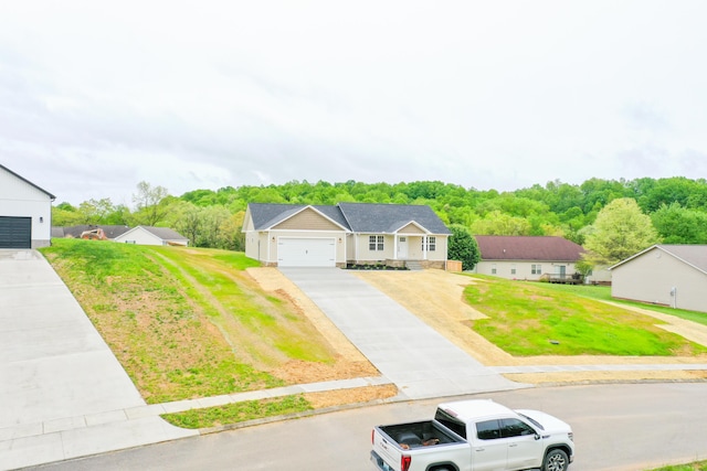 single story home featuring driveway, a front lawn, and an attached garage
