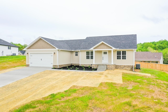 craftsman inspired home with driveway, central AC, fence, an attached garage, and a shingled roof