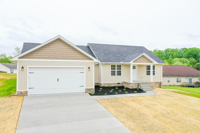 view of front of house featuring driveway, a garage, covered porch, and a shingled roof