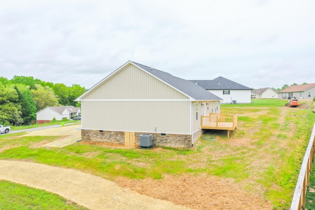 view of property exterior with crawl space, central AC, a wooden deck, and a lawn