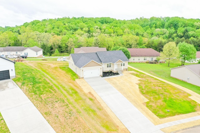 aerial view of property and surrounding area featuring a heavily wooded area