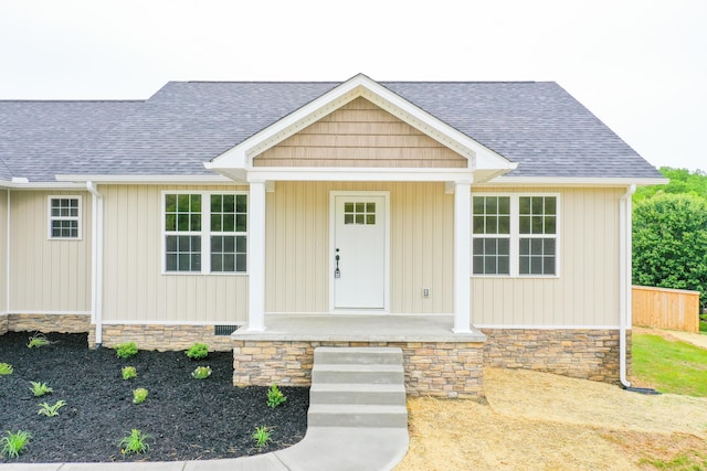 view of front of house with stone siding and a shingled roof