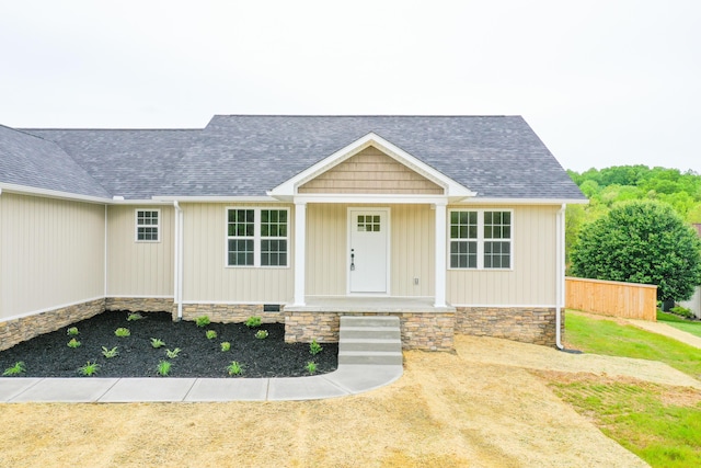 view of front facade featuring a shingled roof and a porch