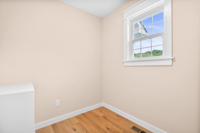 unfurnished room with baseboards and light wood-style floors