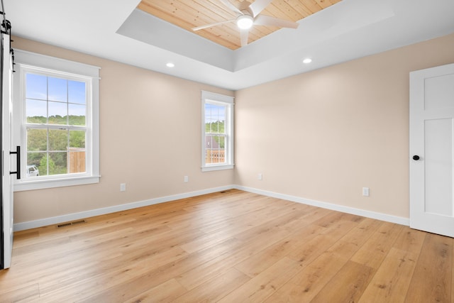 spare room featuring light wood finished floors, plenty of natural light, baseboards, ceiling fan, and wooden ceiling