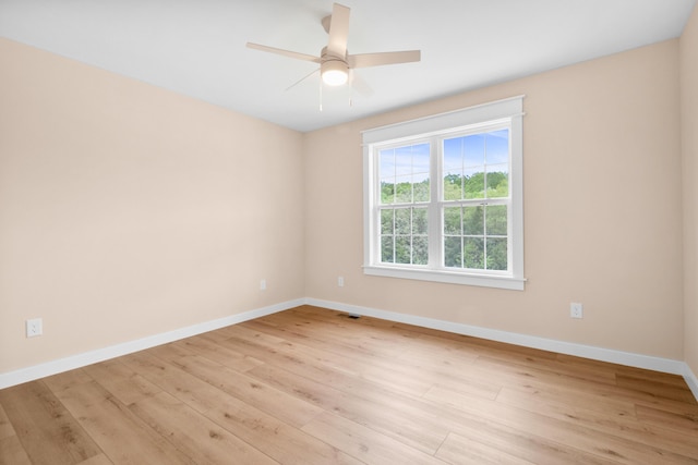 empty room featuring baseboards, light wood-style flooring, and ceiling fan