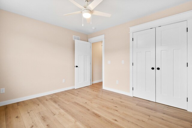 unfurnished bedroom featuring light wood-style flooring, baseboards, a closet, and a ceiling fan