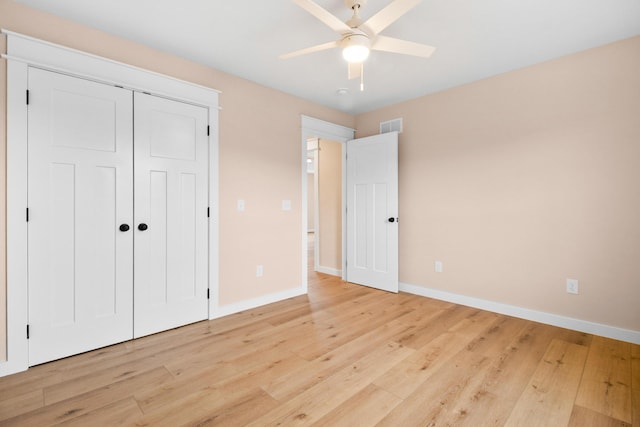 unfurnished bedroom with baseboards, light wood finished floors, and a closet