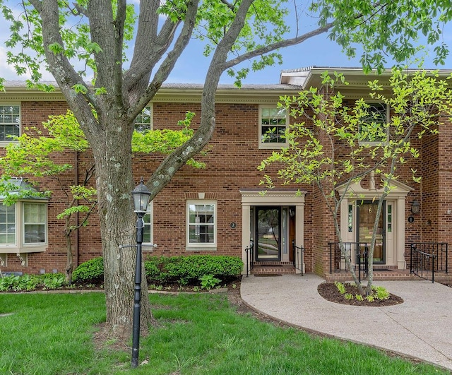 view of property with a front yard and brick siding
