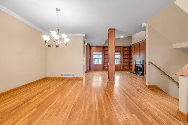 interior space featuring baseboards, ornamental molding, light wood finished floors, visible vents, and a chandelier