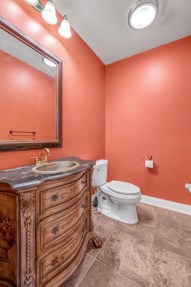 bathroom featuring vanity, toilet, and baseboards