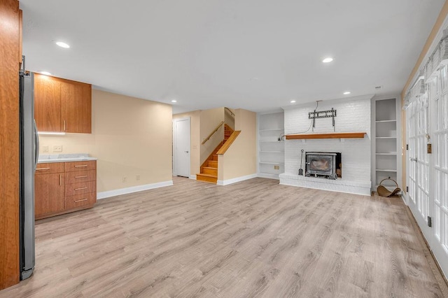 unfurnished living room with light wood-style flooring, stairs, baseboards, and recessed lighting
