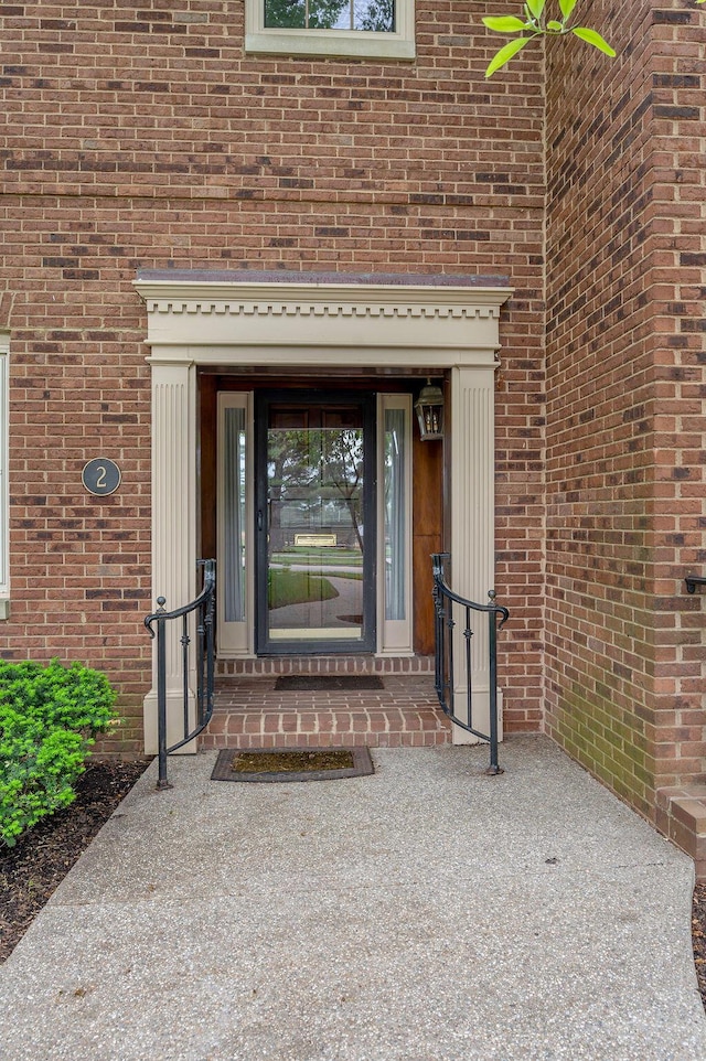 view of exterior entry featuring brick siding