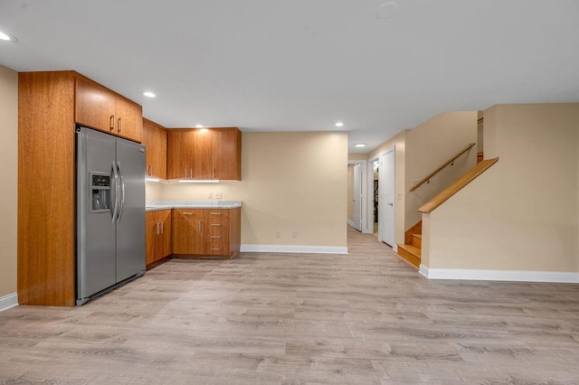 kitchen with baseboards, brown cabinets, stainless steel fridge with ice dispenser, and light wood-style flooring