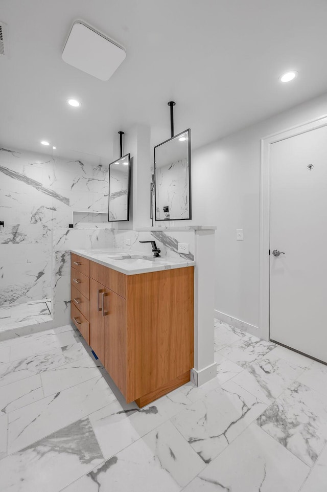 full bath featuring recessed lighting, marble finish floor, a sink, double vanity, and a marble finish shower