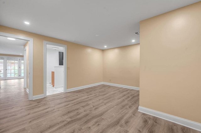 below grade area with visible vents, light wood-style flooring, baseboards, and recessed lighting