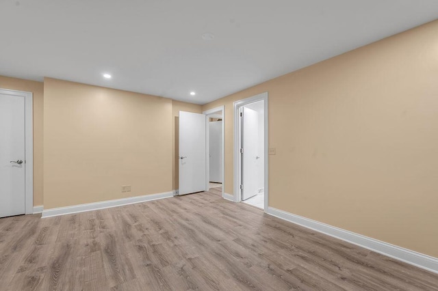 empty room with baseboards, recessed lighting, and wood finished floors