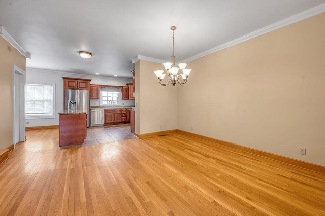 kitchen with a chandelier, stainless steel appliances, crown molding, and light wood-type flooring