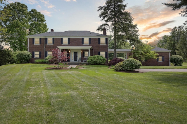 view of front facade with brick siding and a front lawn