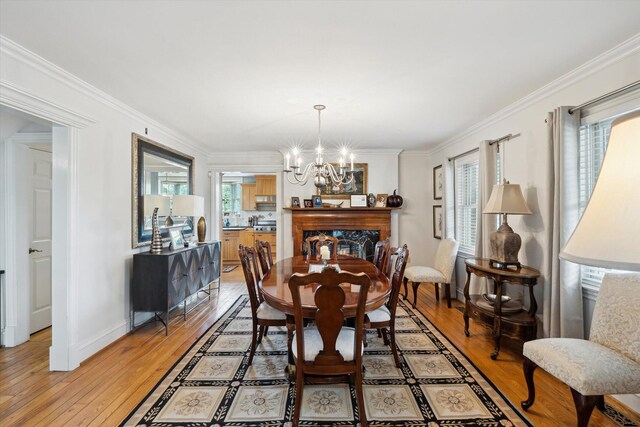 dining room with a chandelier, wood finished floors, and ornamental molding