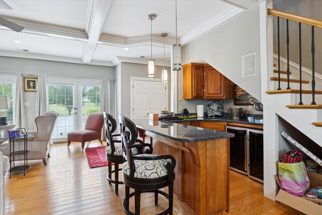 living area with light wood-style floors, crown molding, a ceiling fan, stairs, and coffered ceiling