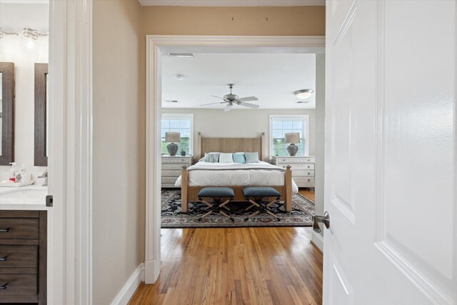 full bath with wood finished floors, double vanity, baseboards, and recessed lighting