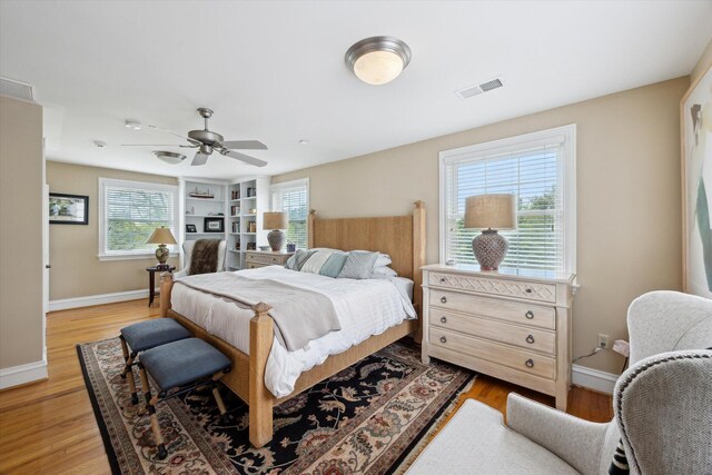 bedroom with light wood-style floors, baseboards, and a ceiling fan