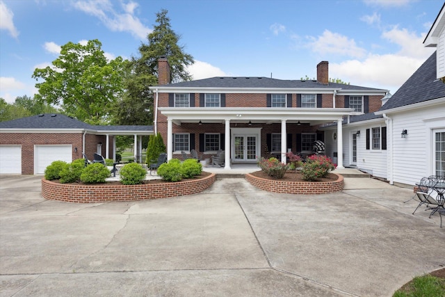 back of property with a chimney, brick siding, french doors, and a ceiling fan