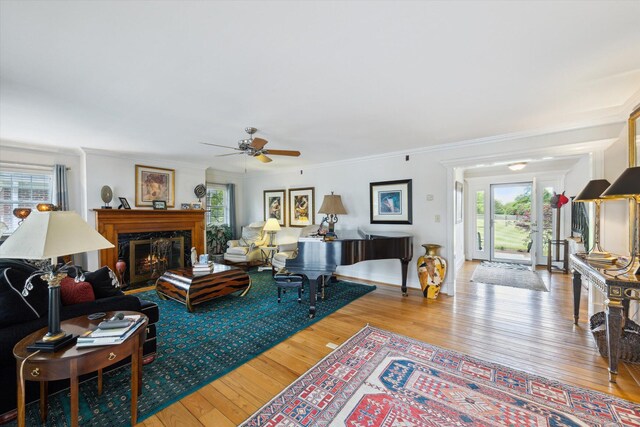 living room with french doors, hardwood / wood-style floors, crown molding, and a ceiling fan