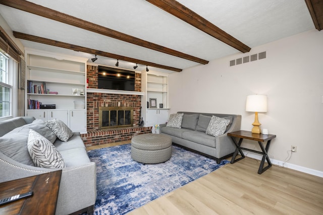 2912 Jason Ct, Lexington, KY 40503 - living area featuring wood finished floors, beam ceiling, baseboards, and a brick fireplace