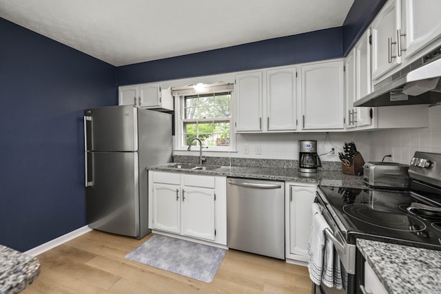 2912 Jason Ct, Lexington, KY 40503 - kitchen with appliances with stainless steel finishes, a sink, under cabinet range hood, white cabinets, and dark stone countertops