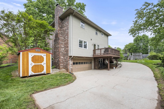 2912 Jason Ct, Lexington, KY 40503 - view of side of property with a storage shed, concrete driveway, a chimney, a garage, and a wooden deck