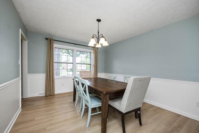 2912 Jason Ct, Lexington, KY 40503 - dining room with light wood finished floors, a chandelier, a textured ceiling, and baseboards
