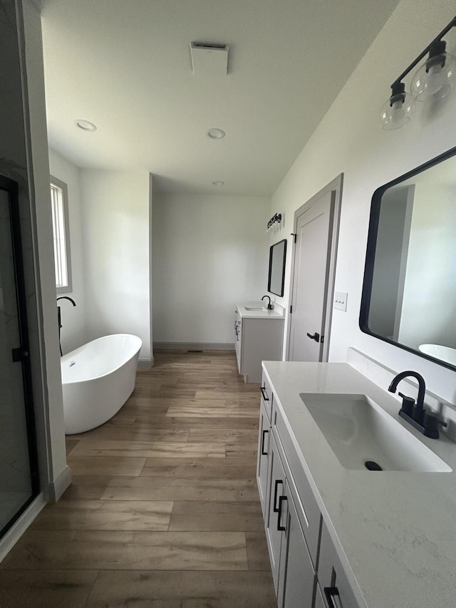 66 Driftwood Way, Corbin, KY 40701 - bathroom with vanity, a soaking tub, wood finished floors, baseboards, and recessed lighting