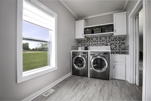 laundry room with separate washer and dryer, cabinet space, light wood-type flooring, ornamental molding, and baseboards