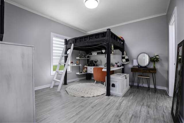 bedroom featuring crown molding, wood finished floors, baseboards, and a desk