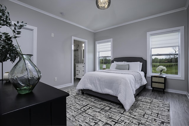 bedroom with ornamental molding, wood finished floors, baseboards, and connected bathroom