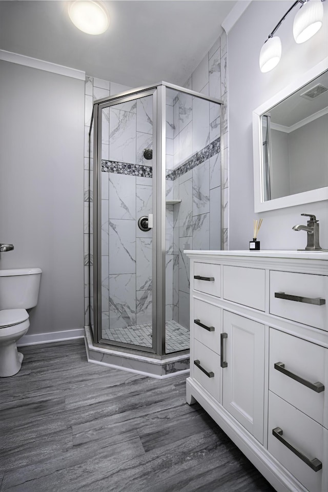 full bathroom with toilet, a stall shower, vanity, and wood finished floors