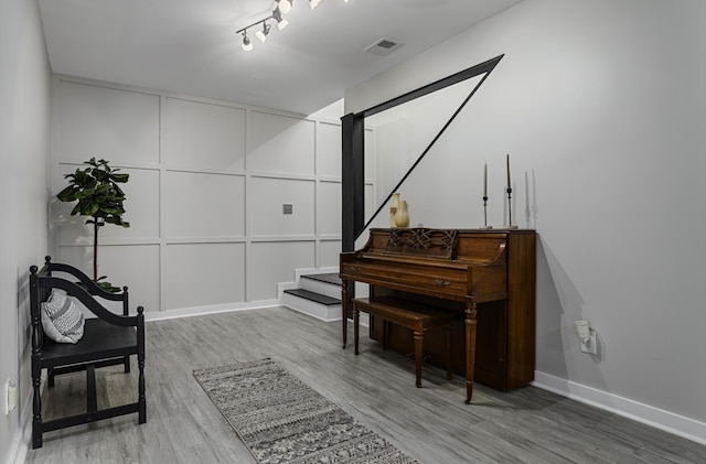 sitting room with light wood finished floors, stairway, and baseboards