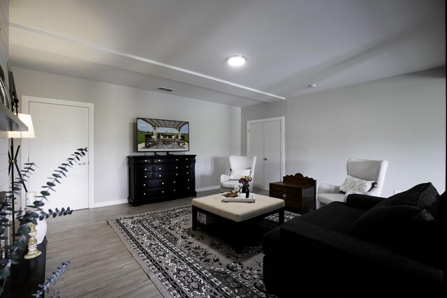 living room featuring wood finished floors, baseboards, and recessed lighting