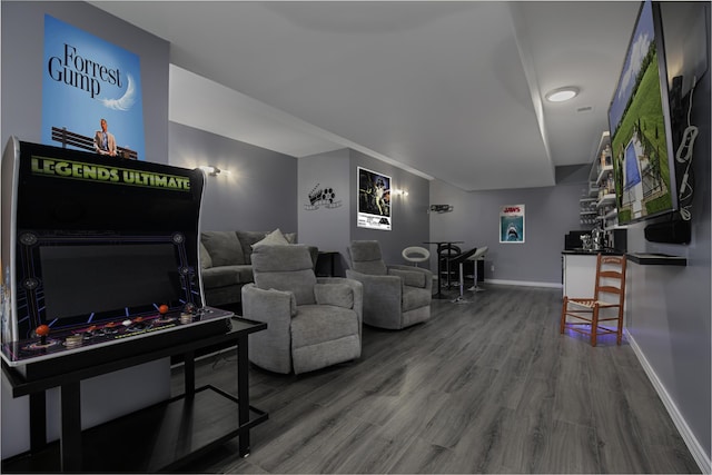 living room with wood finished floors, baseboards, and a bar