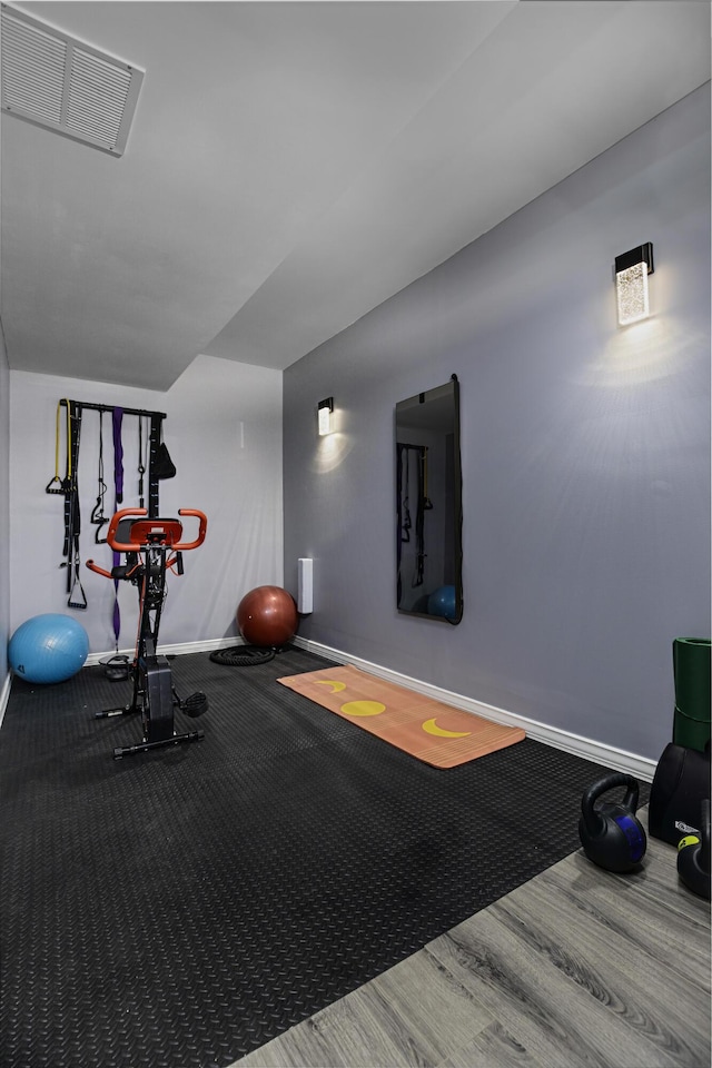 workout room with baseboards and wood finished floors
