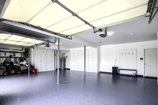 garage featuring a garage door opener, electric water heater, and baseboards