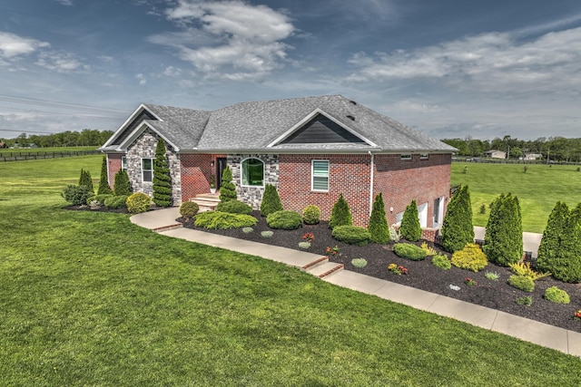 view of front facade with a front lawn, brick siding, stone siding, an attached garage, and a shingled roof