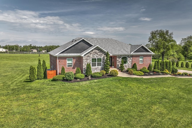 craftsman house featuring a front lawn, a shingled roof, and stone siding