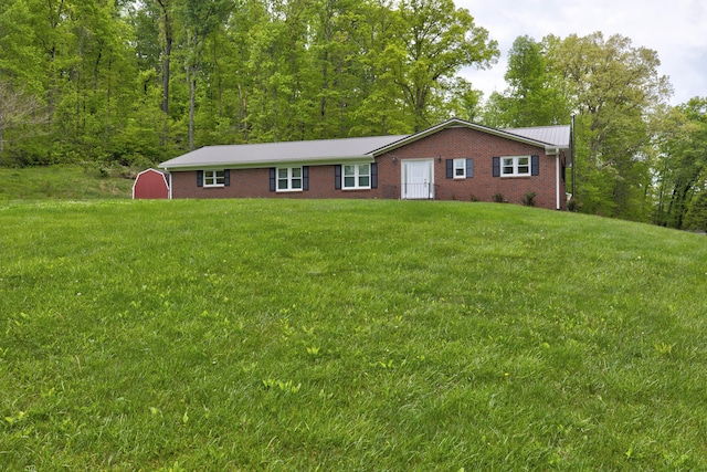246 Pottersville Rd, Means, KY 40346 - ranch-style house with a front yard, brick siding, metal roof, a shed, and an outbuilding