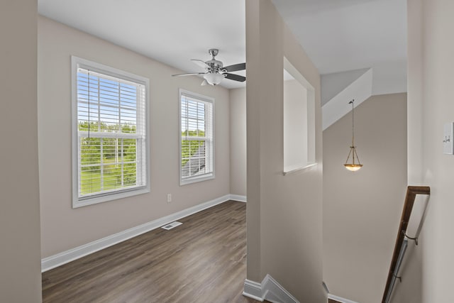 spare room with baseboards, dark wood-style flooring, and ceiling fan