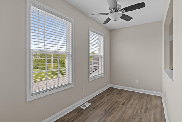 empty room featuring baseboards, wood finished floors, and a ceiling fan